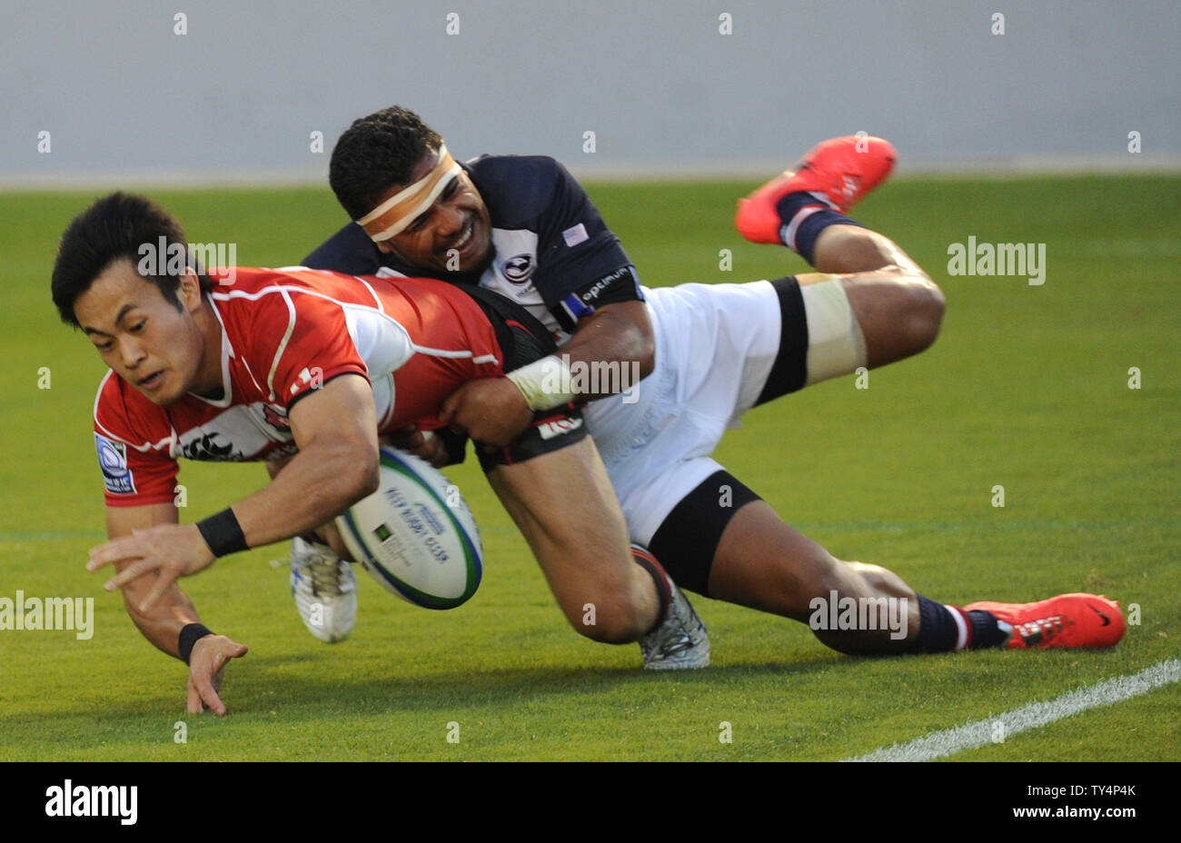 USA's Folau Niua, droite, s'attaque au Japon Kenki de Fukuoka et lui cause de laisser tomber la balle alors qu'il tente de marquer dans le Rugby Pacific Nations Cup à l'StubHub Center de Carson, en Californie le 14 juin 2014. UPI/Lori Shepler Banque D'Images