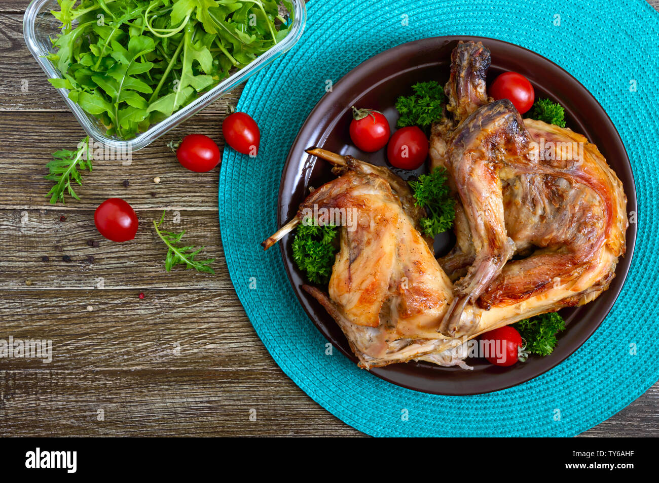 Lapin cuit entier avec les verts et les tomates sur une assiette. Diététique savoureuse viande. Haut de la vue, télévision lay. Banque D'Images