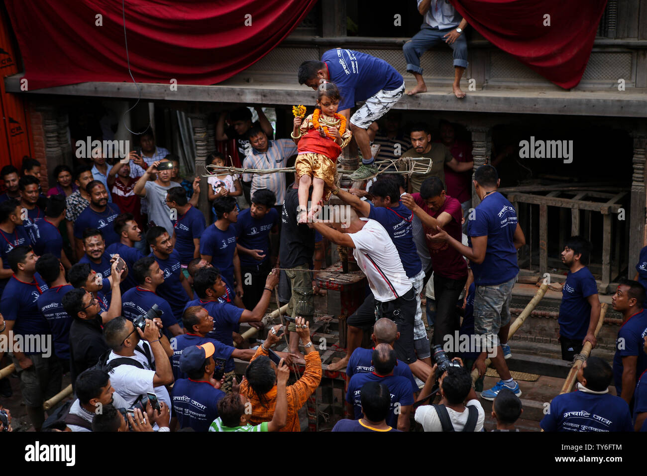 Katmandou, Népal. 25 Juin, 2019. Les soldes d'un enfant sur les pointes des dents en bois par les dévots pendant la procession de Trishul Jatra ou Tridents.Festival Le festival est célébré par les dévots hindous et les parents qui estiment que leurs enfants seront bénis avec une bonne santé après avoir participé dans les rituels. Credit : SOPA/Alamy Images Limited Live News Banque D'Images