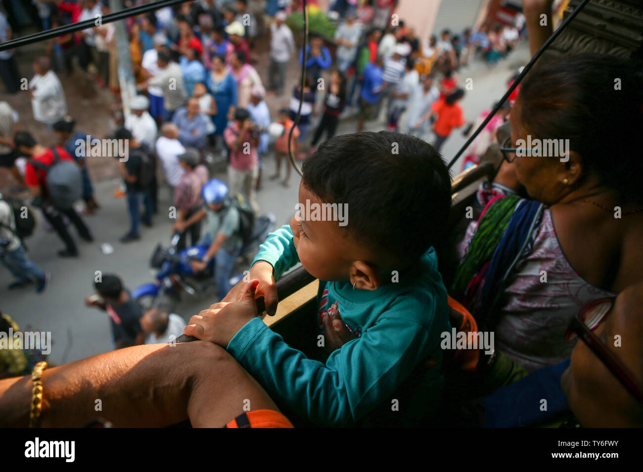 Katmandou, Népal. 25 Juin, 2019. Un enfant avec ses parents regarder la procession de Trishul Jatra ou Tridents.Festival Le festival est célébré par les dévots hindous et les parents qui estiment que leurs enfants seront bénis avec une bonne santé après avoir participé dans les rituels. Credit : SOPA/Alamy Images Limited Live News Banque D'Images