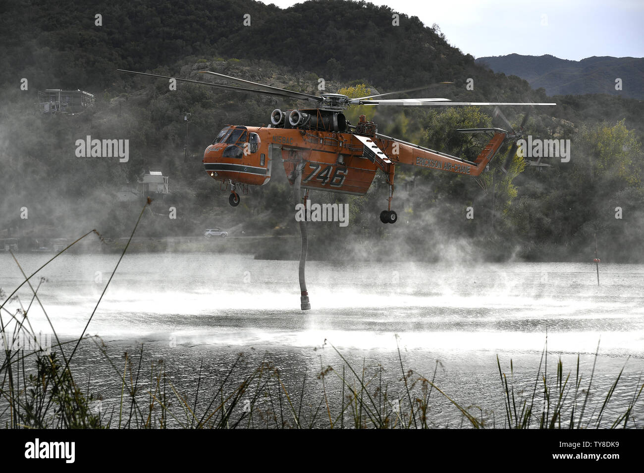 Une chute d'eau Grue Ericson hélicoptère Sky remplit son réservoir avec un tuba en le plongeant dans le lac Sherwood à Westlake Village, en Californie le 13 novembre 2018. Selon les responsables locaux, les incendies font rage dans le Nord et le Sud de la Californie ont tué au moins 31 personnes, détruit des milliers d'ouvrages et d'environ 150 000 personnes forcées d'évacuer. Photo de John McCoy/UPI Banque D'Images