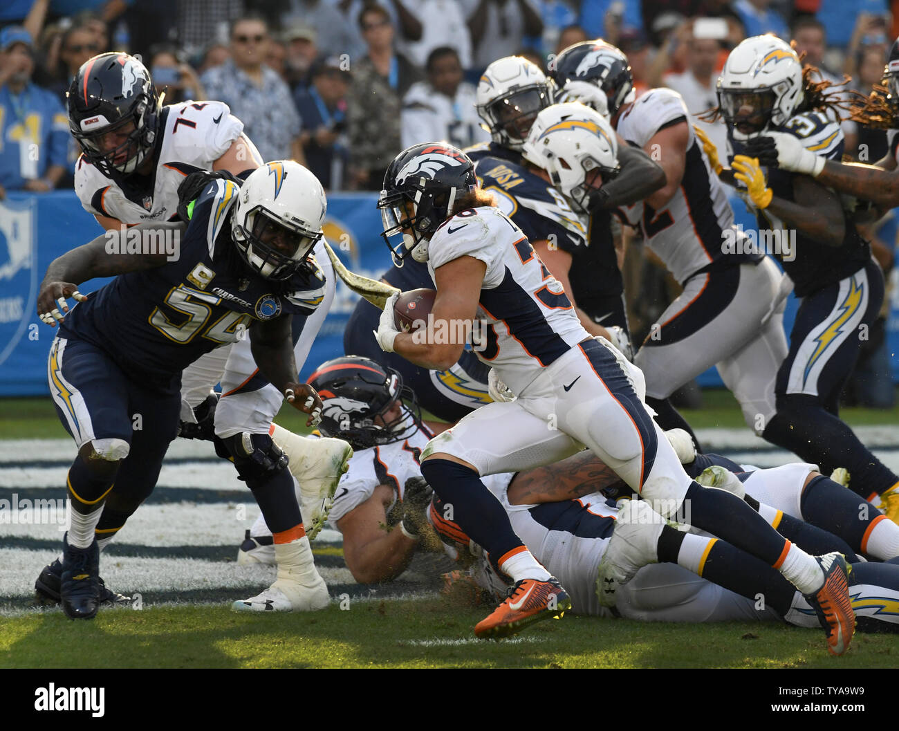 Les running back Phillip Lindsay (30) marque un touchdown passé fin des Chargers Melvin Ingram III (54) à StubHub Center de Carson, en Californie le 18 novembre 2018. Photo par Jon SooHoo/UPI Banque D'Images