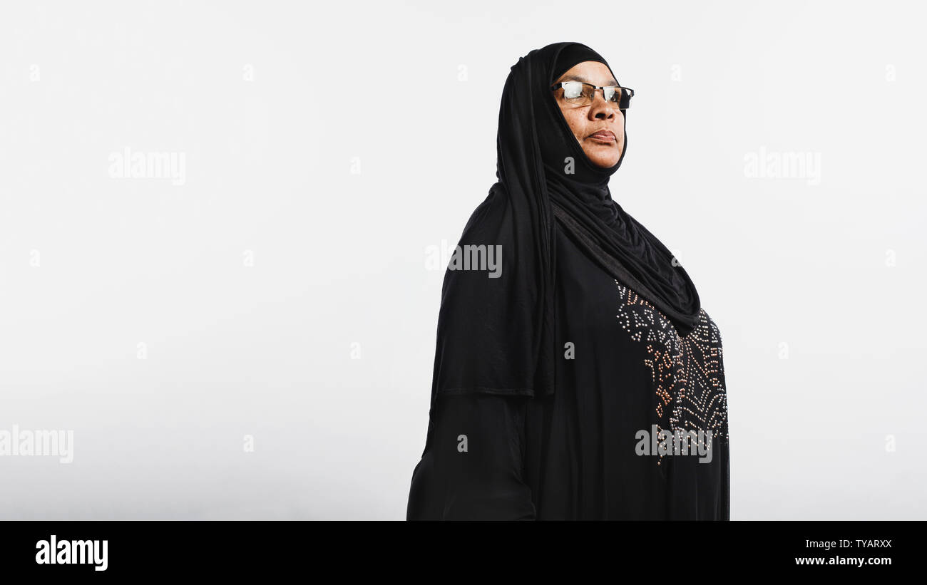 Les femme en hijab isolé sur fond blanc. Smiling woman arabe dans les lunettes et d'un hijab noir à la voiture. Banque D'Images