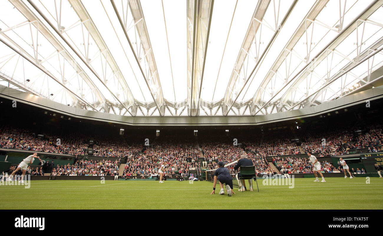 La star du tennis américain Andre Agassi sert la balle lors d'un match de double mixte avec l'épouse Steffi Graf contre la Grande-Bretagne Tim Henman et Kim Clijsters. Le match a été joué à célébrer le premier jeu sur le nouveau court central de Wimbledon avec le toit complètement fermé le dimanche 17 mai 2009. (Photo d'UPI/Hugo Philpott) Banque D'Images