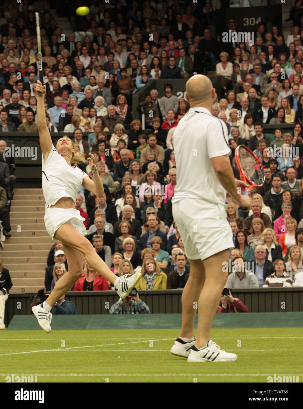 La star du tennis américain Andre Agassi, regarde sa femme Steffi Graf jouer un point dans le match de double mixte contre la Grande-Bretagne Tim Henman et Kim Clijsters. Le match a été joué à célébrer le premier jeu sur le nouveau court central de Wimbledon avec le toit complètement fermé le dimanche 17 mai 2009. (Photo d'UPi/Hugo Philpott) Banque D'Images