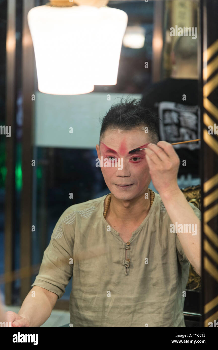 L'acteur chinois traditionnel s'applique du maquillage avant un spectacle dans un théâtre chinois. Photographié à Chengdu, Sichuan, Chine Banque D'Images