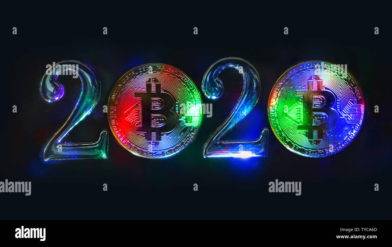 Le concept de 2020 sur le thème de l'cryptocurrency. Multi-couleur pièces bitcoin se tenir à côté des numéros 2. Fond noir. Banque D'Images