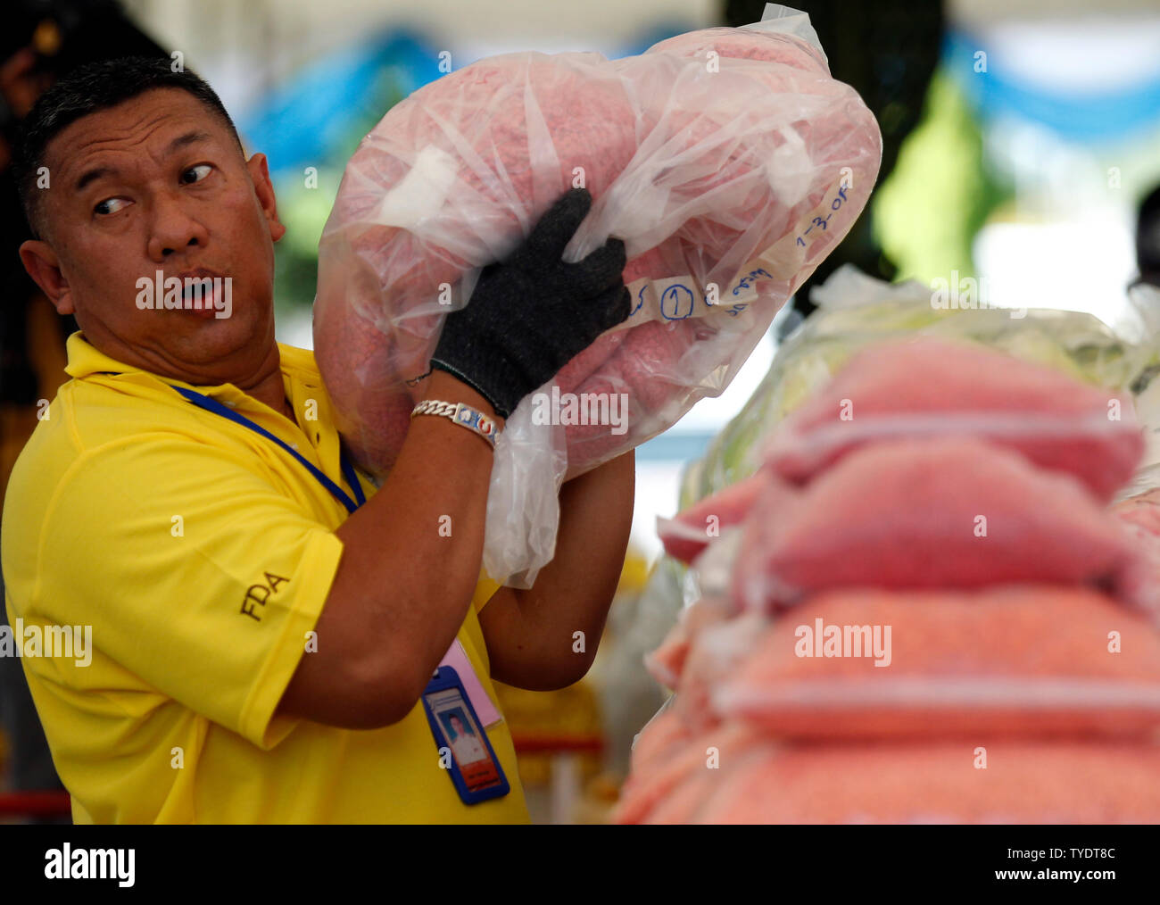 Un Thaï officielle des stupéfiants organise des sacs de comprimés de méthamphétamine au cours de la 49e la destruction des stupéfiants confisqués de la cérémonie pour marquer la Journée internationale contre l'abus et le trafic illicite de province d'Ayutthaya, au nord de Bangkok.Plus de 16 467 kg de drogues, dont la méthamphétamine, la marijuana, l'héroïne et d'opium, d'une valeur de plus de 600 millions de dollars, ont été détruits, le gouvernement thaïlandais a commencé sa campagne anti-drogue, selon le Ministère thaïlandais de la santé publique. Banque D'Images