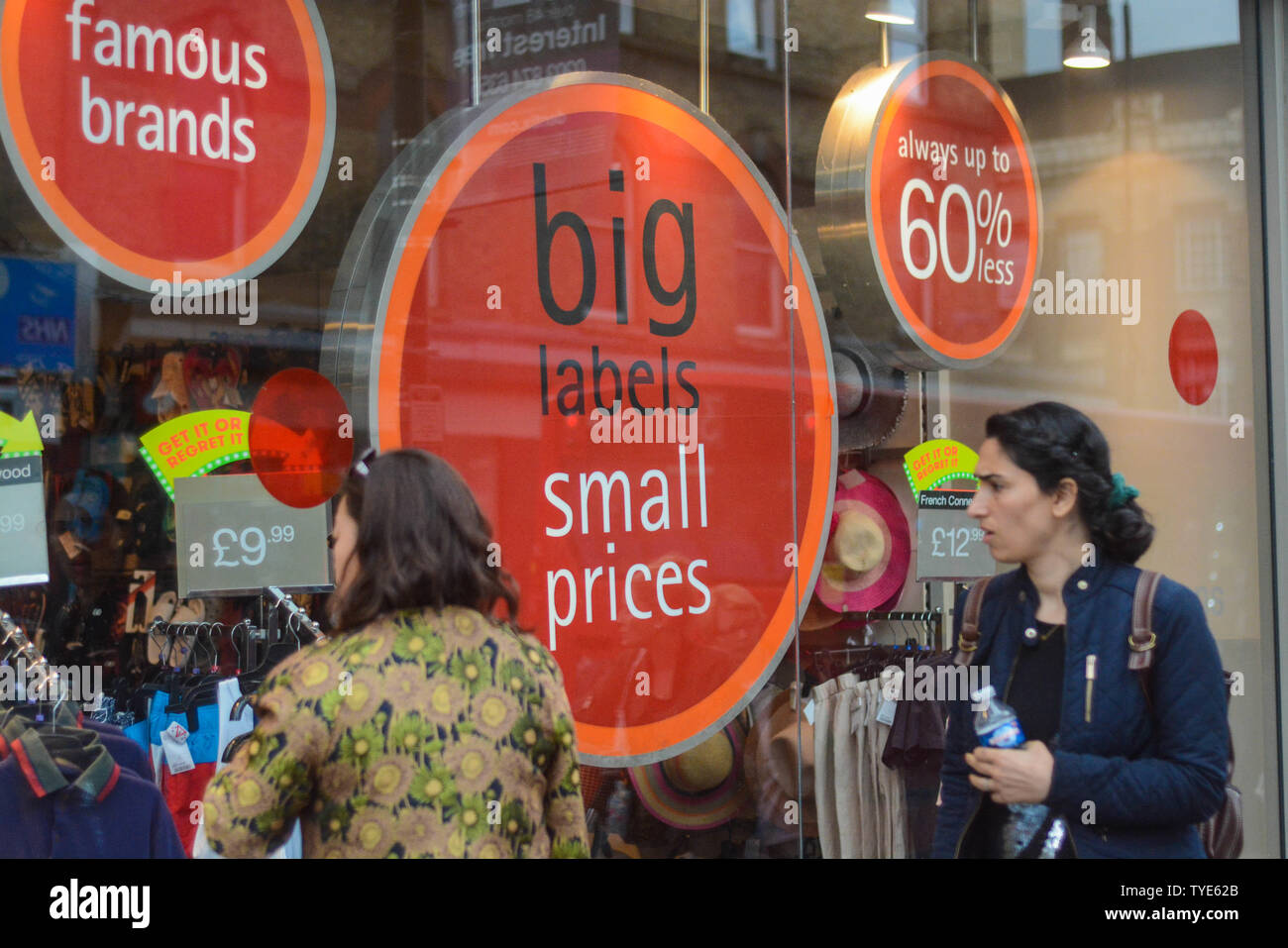 Grandes ventes annoncé sur la vitrine. Les piétons à travers la fenêtre. Banque D'Images