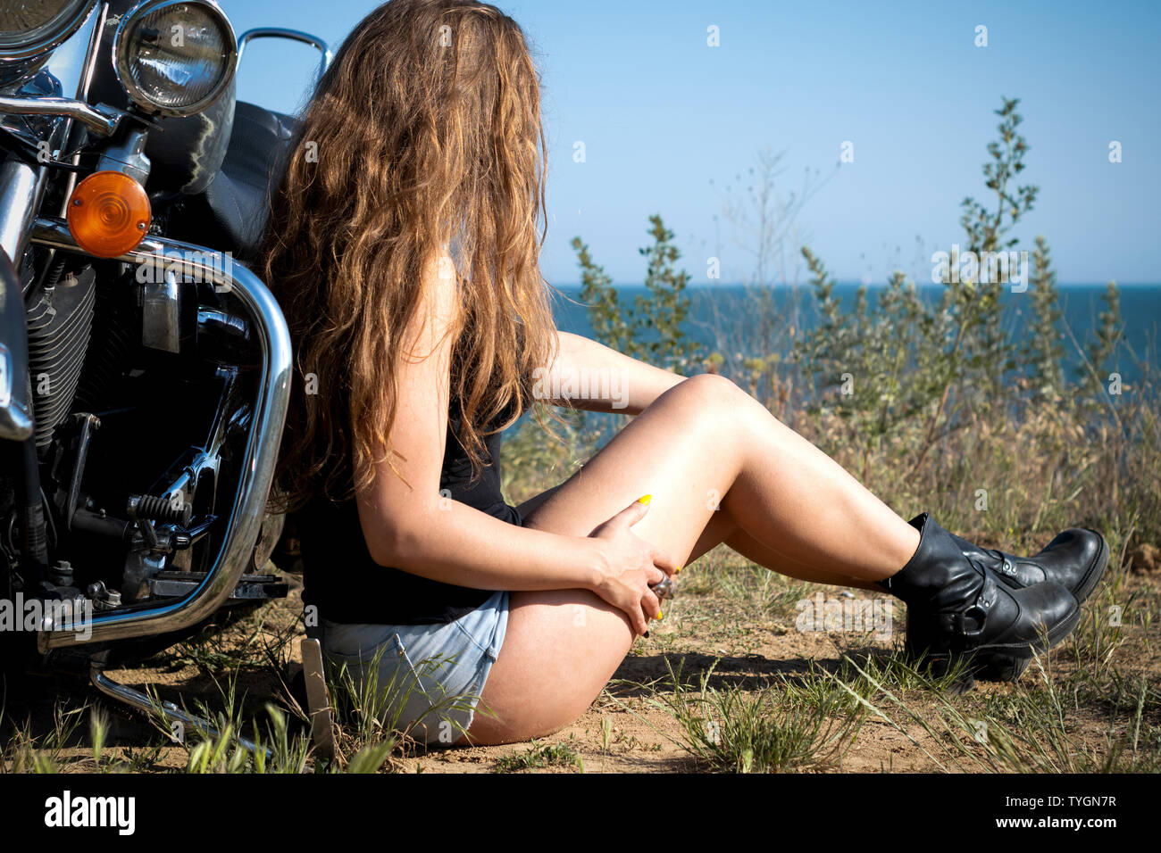 Moto dame en short et bottes en cuir assis près de moto. biker fille Photo  Stock - Alamy