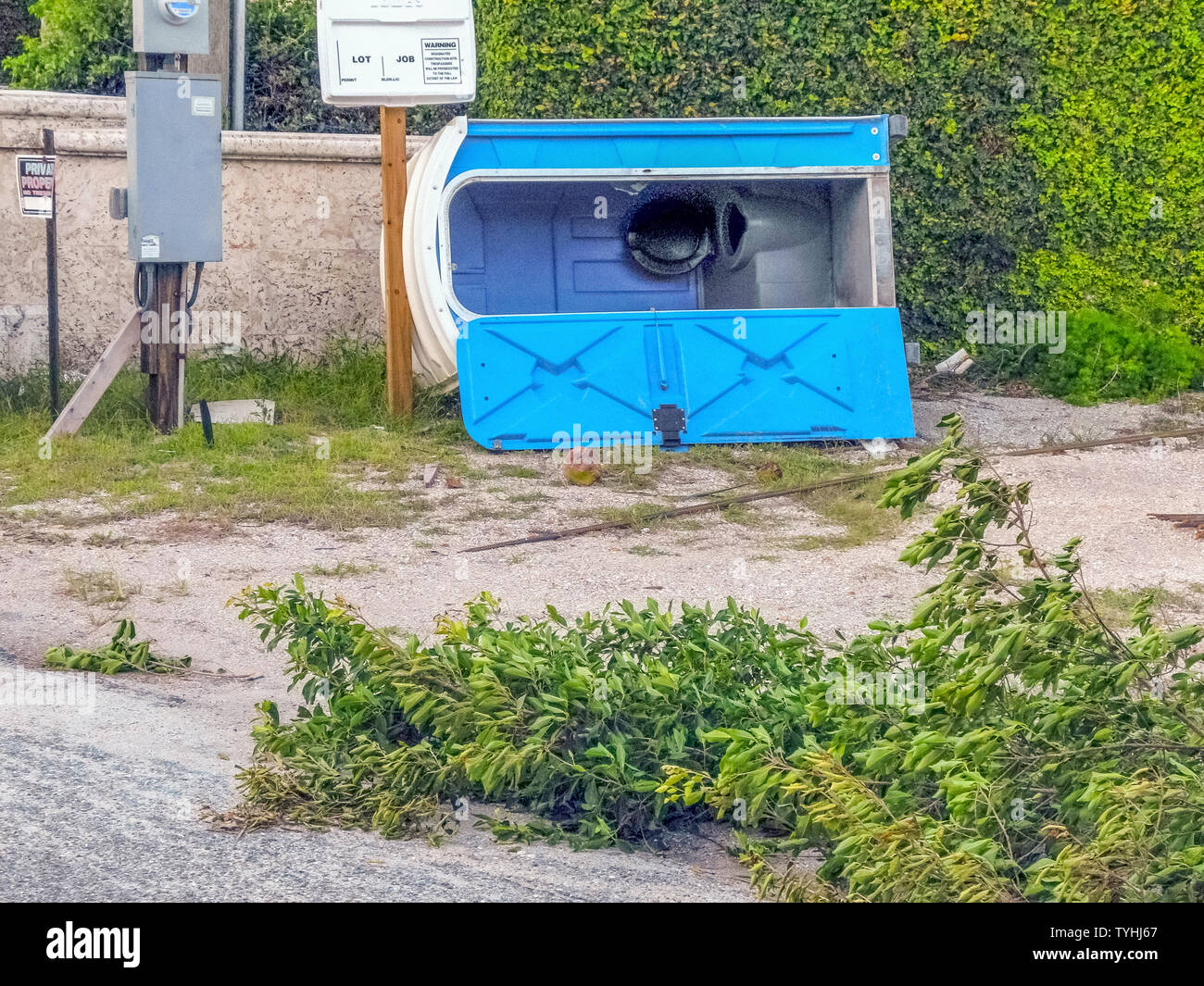 Un portable toilettes de plein air repose sur le côté après avoir été renversé lors d'une tempête de l'ouragan qui a arraché des branches d'arbre en Floride, USA. La plupart des toilettes portables sont des cabines en plastique moulé qui servent les besoins sanitaires d'une personne à la fois et sont généralement requis sur les chantiers de construction et à l'extérieur des événements publics. Bien que les modèles de base n'ont qu'un siège sur la cuvette, et parfois d'un urinoir, les modèles de luxe disposent d'une chasse wc, lavabo, miroir, savon, serviettes en papier et un intérieur lumineux. Certains sont construits pour accueillir les handicapés. Banque D'Images