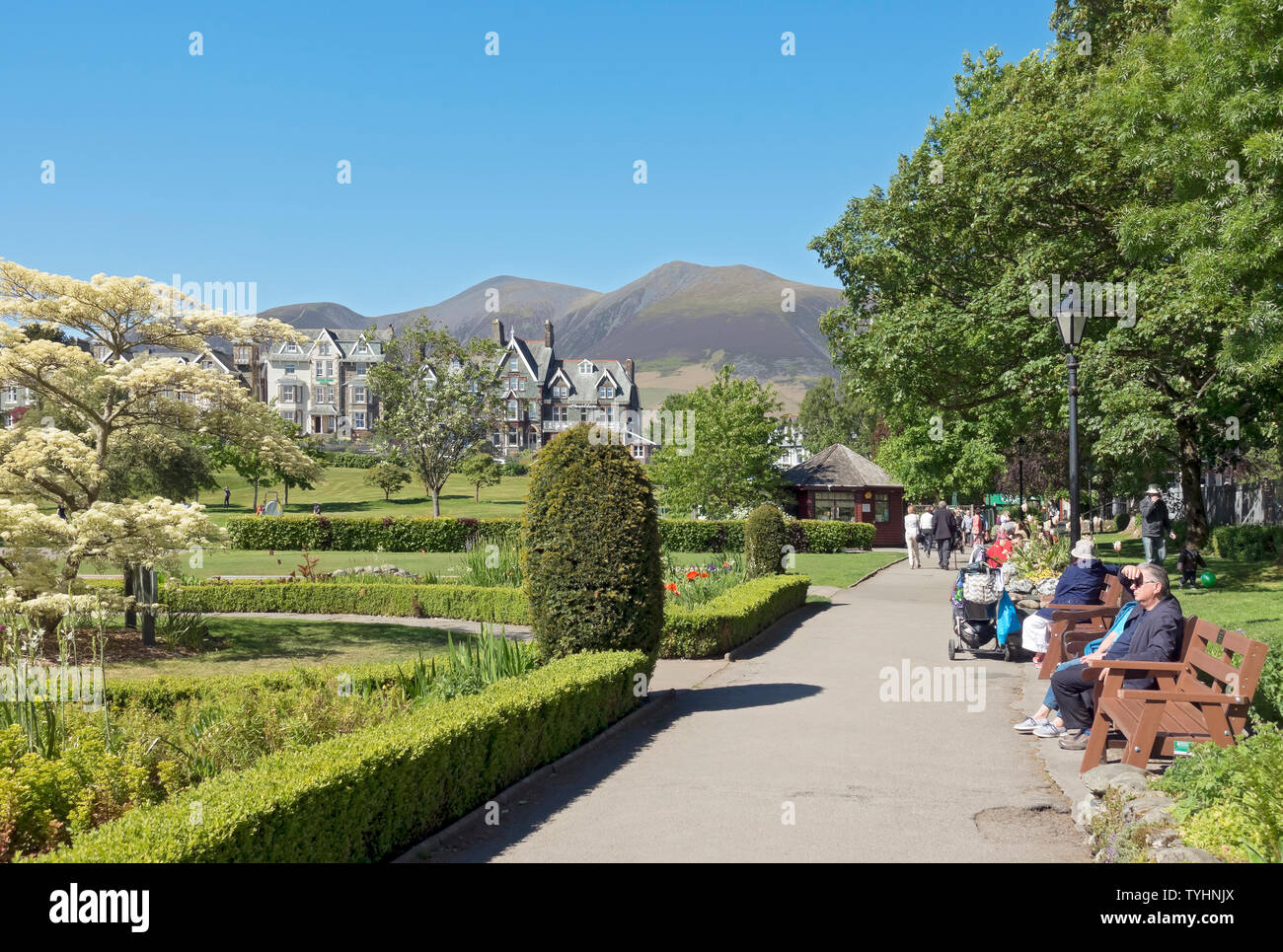 Les visiteurs touristes se détendant dehors dans l'été soleil Hope Park Keswick Cumbria Angleterre Royaume-Uni Grande-Bretagne Banque D'Images