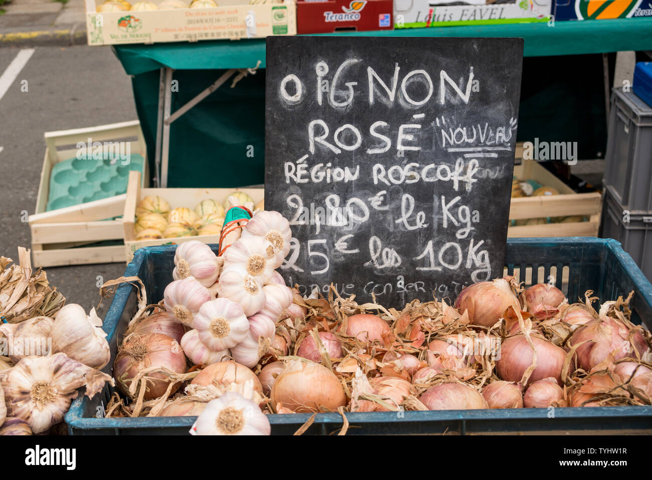 La vente de bulbes de décrochage ails et oignons au marché hebdomadaire du jeudi à Dinan, Bretagne, France Banque D'Images