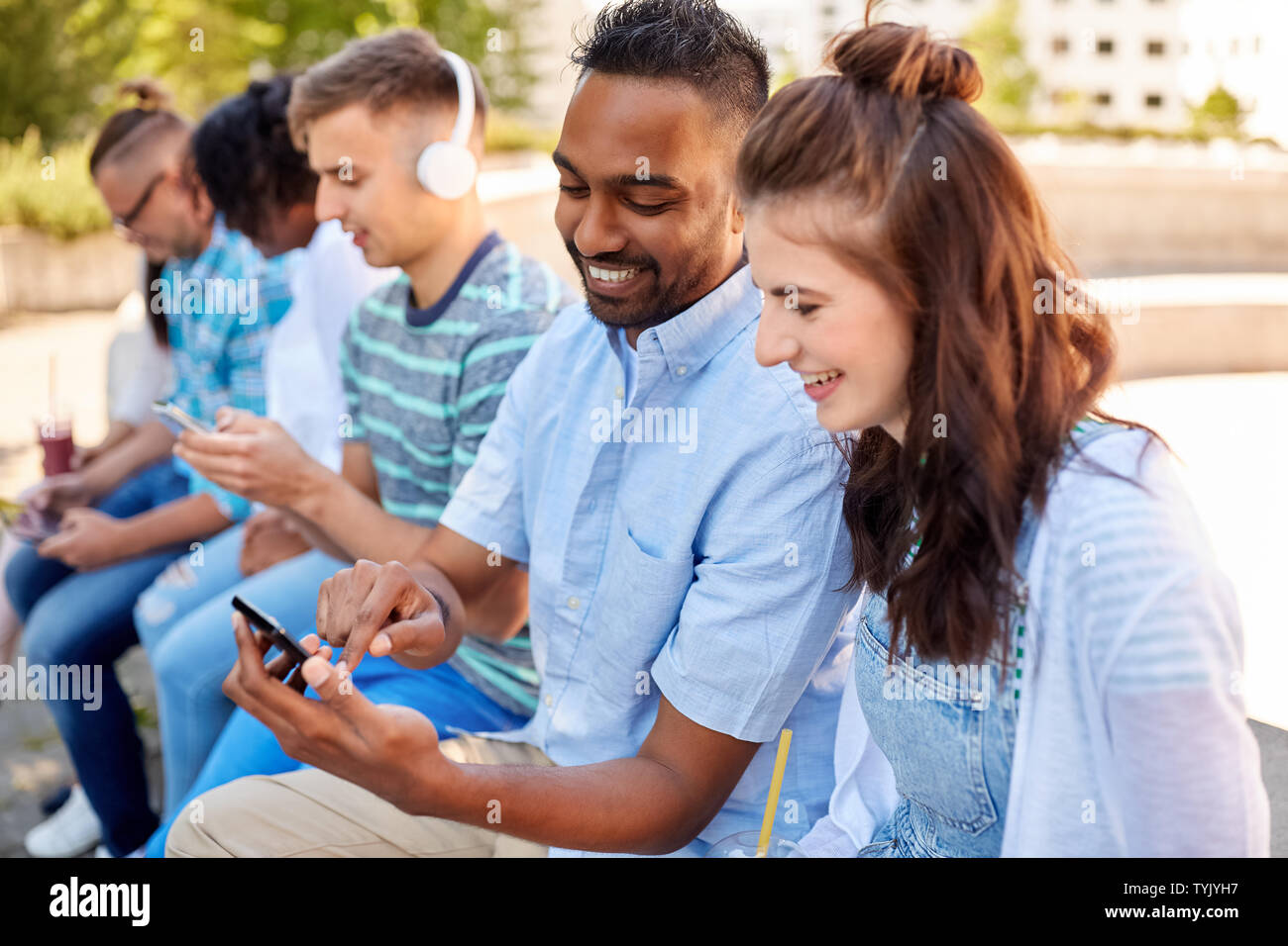 Amis avec les smartphones et les tablet pc en ville Banque D'Images