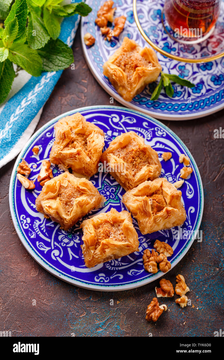 Dessert traditionnel arabe baklava aux noix sur une plaque décorative. Banque D'Images