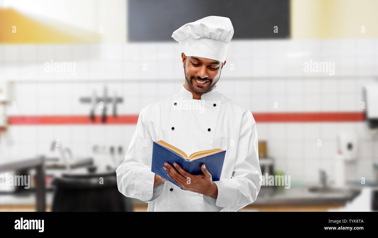Happy chef indien lecture livre de cuisine à Banque D'Images