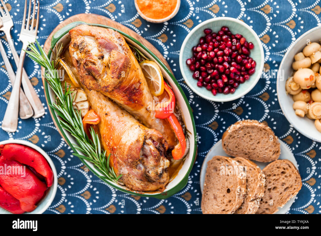 Plat de fête pour Thanksgiving, rôti de dinde jambes avec des légumes sur une table avec des collations. Banque D'Images