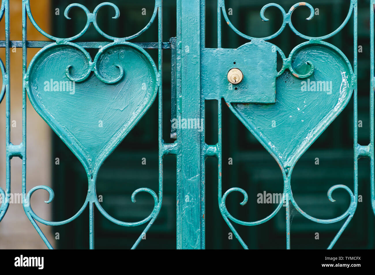 Close-up d'un caillebotis turquoise avec des ornements en forme de coeur et d'un verrou d'or avec le symbole de la couronne, l'arrière-plan flou - l'orientation paysage Banque D'Images
