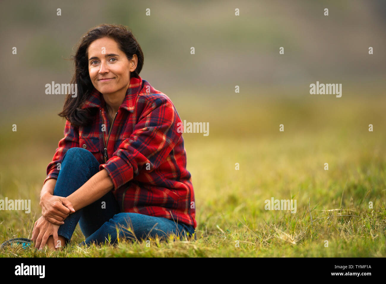 Portrait of a Mid adult woman sitting dans les champs. Banque D'Images