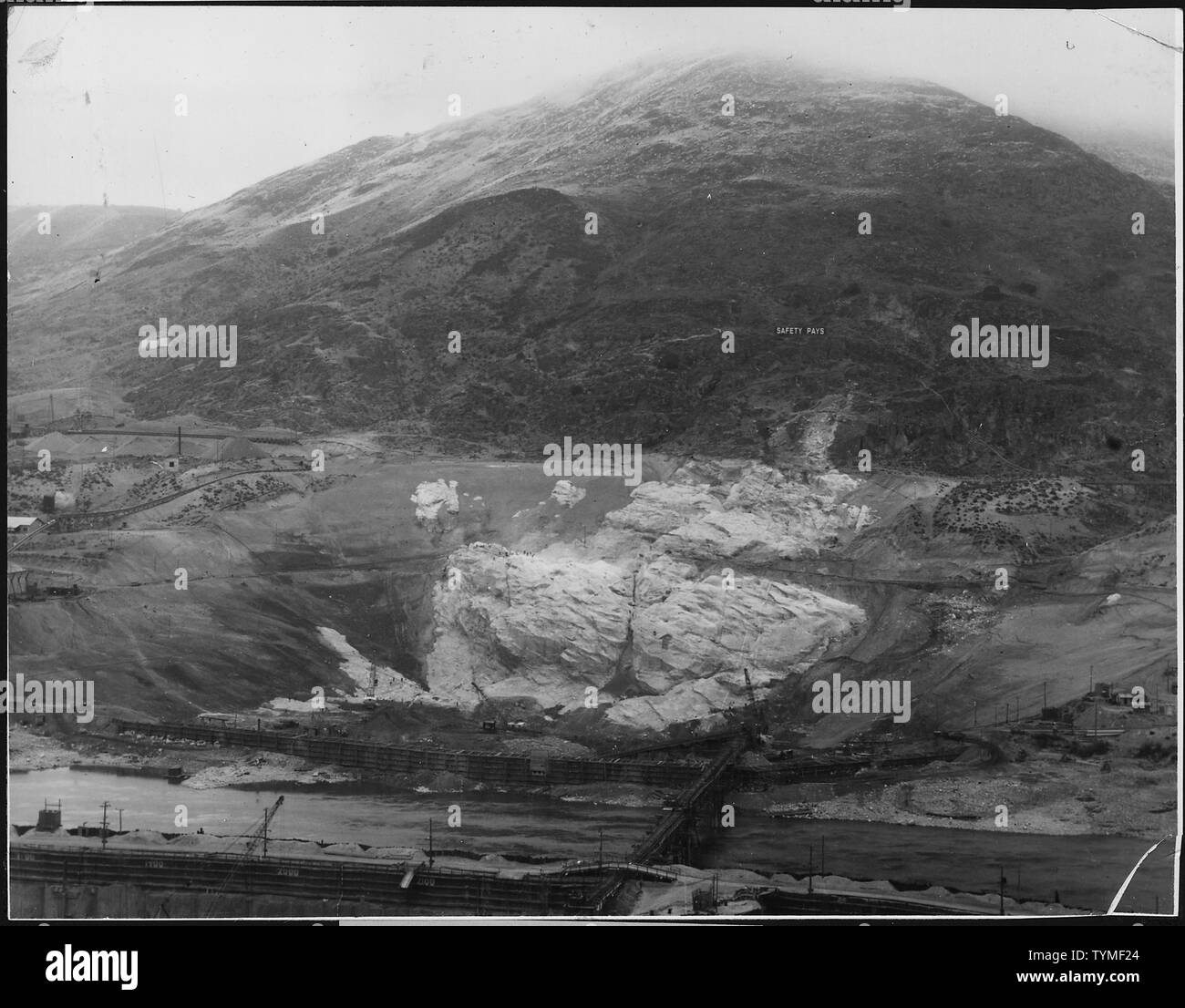 Le côté est bien avec la vue de face de la rivière east side, batardeaux bois mur roche exposée sur le pilier et le chevalet de bois portant le convoyeur à bande de 60 pouces de l'autre côté de la rivière. ; Portée et contenu : la photographie de deux volumes d'une série d'albums de photos documentant la construction du barrage de Grand Coulee et travaux connexes sur le bassin du Columbia Projet. Banque D'Images