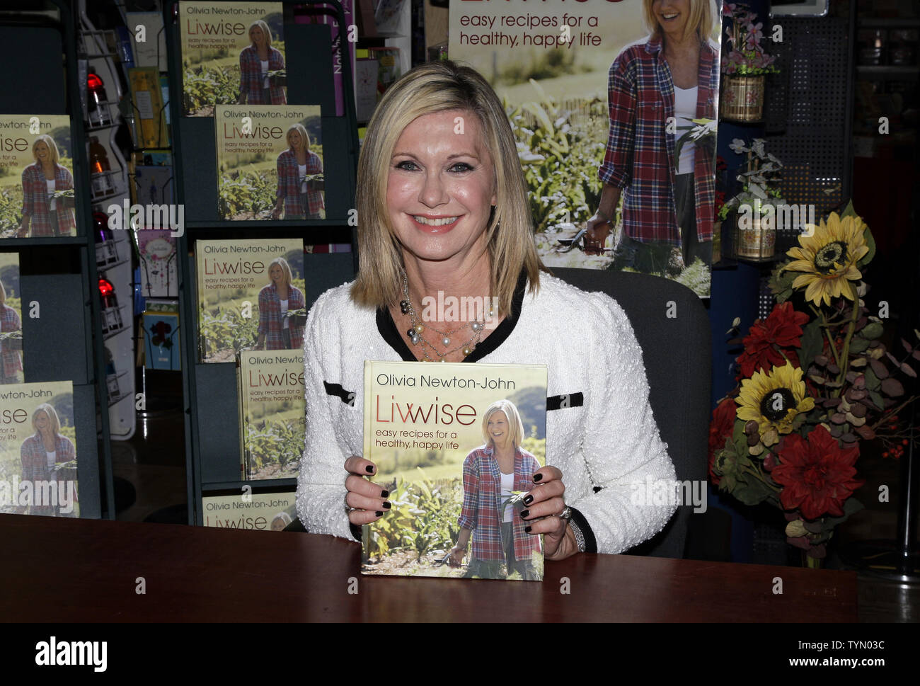 Olivia Newton-John siège avec une copie de son nouveau livre 'Livwise' à un livre de signature au Barnes & Noble à New York le 27 avril 2012. UPI/John Angelillo Banque D'Images