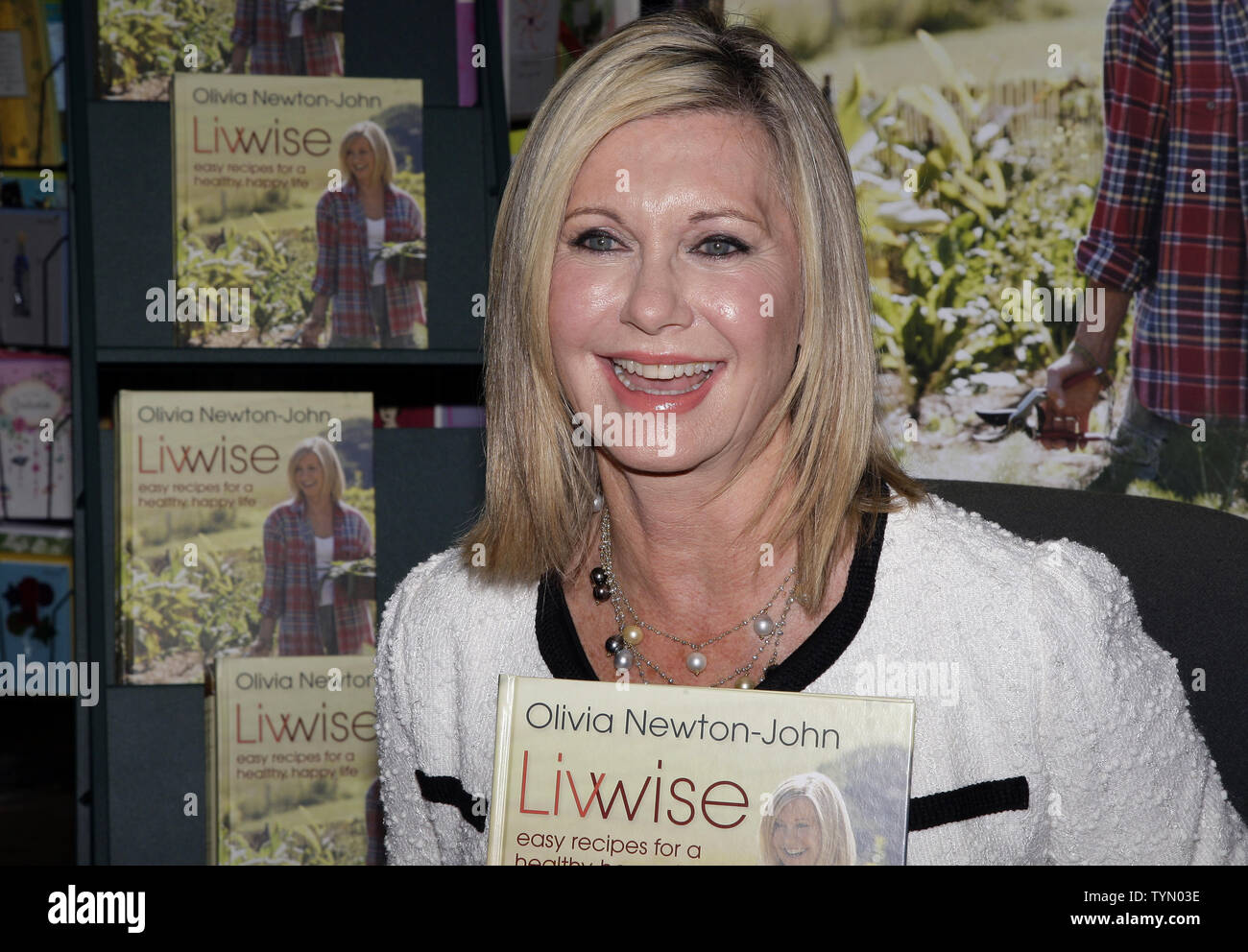 Olivia Newton-John siège avec une copie de son nouveau livre 'Livwise' à un livre de signature au Barnes & Noble à New York le 27 avril 2012. UPI/John Angelillo Banque D'Images