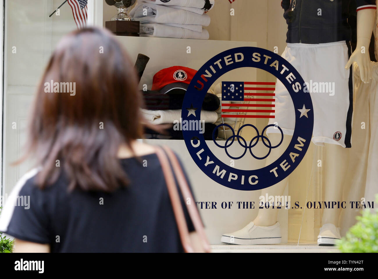 Les piétons marchent par affiche des USA Olympics les vêtements à la boutique Ralph Lauren sur Lexington Avenue à New York le 13 juillet 2012. Plusieurs législateurs, surtout Démocrates, déchargé cette semaine sur le comité olympique américain après les informations selon lesquelles les athlètes américains dans ce ans London Jeux seront tenues d'usure conçu par American Ralph Lauren mais fabriqués principalement en Chine. UPI/John Angelillo Banque D'Images