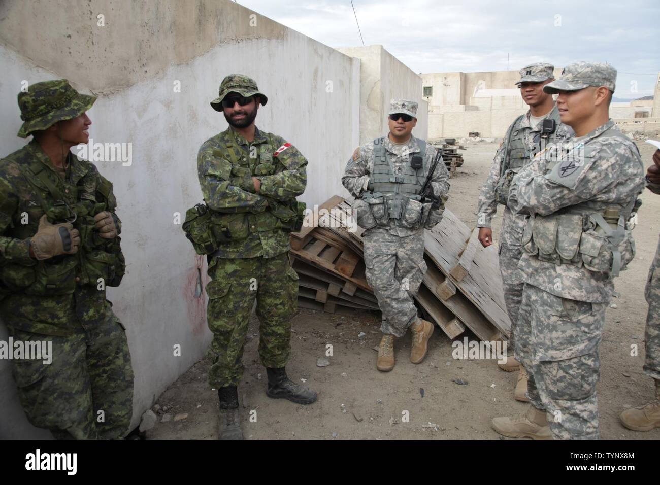 Le Caporal-chef canadien. Paolo Ortega, de la Queen's Own Rifles, Sgt. Suagh Vik du Groupe-brigade du Canada d'interagir avec le personnel de l'armée américaine Jaime Avila, Capt DeAndre Garlington et le Sgt. Hénoc Ko tous les membres du 426e Bataillon des affaires civiles (Airborne), discuter des mesures prises par les membres de l'unité dans la ville fictive de Taclobon à Camp Pendleton, en Californie, au cours d'un chef de mission, le 19 novembre 2016. Exercice TOPHAM est une multinationale, le joint, l'exercice aérien organisé par le 426e Bataillon des affaires civiles à mars Air Reserve Base et Camp Pendleton, en Californie, avec des exercices sur le terrain Banque D'Images