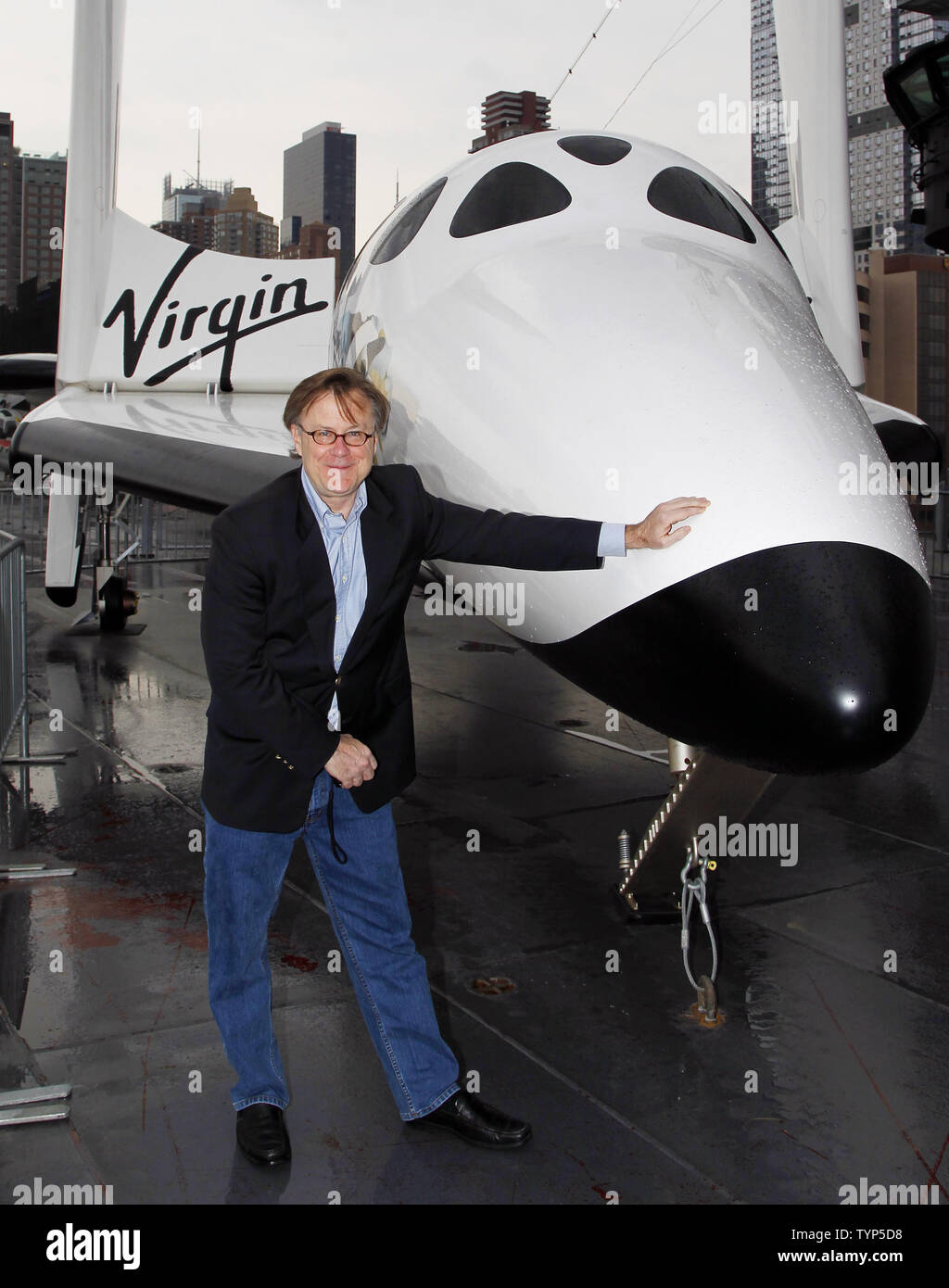 Jim Clash, Virgin Galactic nombre de passagers 610, se tient à côté d'une réplique grandeur nature de la Virgin Galactic SpaceshipTwo, VSS Enterprise spaceship est temporairement sur l'affichage à l'Intrepid Sea, Air & Space Museum de New York City le 22 avril 2014. Le nouveau vaisseau spatial a été mis au point pour le parc de véhicules de Virgin Galactic et est construit pour transporter six clients, ou l'équivalent de la charge utile à la recherche scientifique sur les vols suborbitaux. Les véhicules permettra une expérience de siège avec une vue magnifique sur la planète de le ciel noir de l'espace pour les astronautes de tourisme et de microgravité unique une platfor Banque D'Images