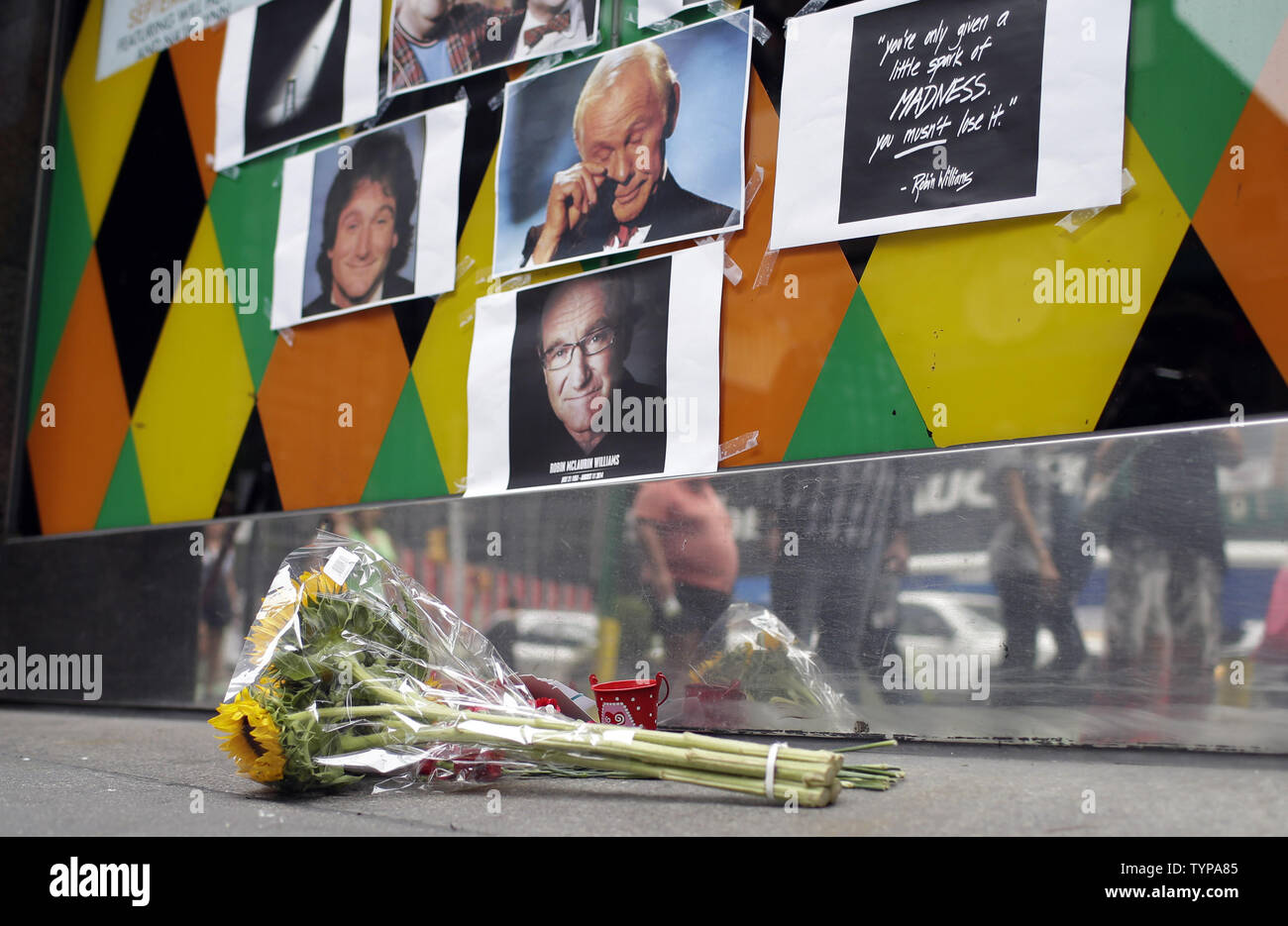 Les gens arrêtent de regarder un hommage et mémorial à la fin de Robin Williams à l'entrée de Carolines sur Broadway comedy club à New York le 12 août 2014. Robin Williams s'est suicidé en se pendant avec une ceinture, le coroner a déclaré mardi dans une conférence de presse détaillant les conclusions préliminaires entourant le décès du comédien et acteur. UPI/John Angelillo Banque D'Images