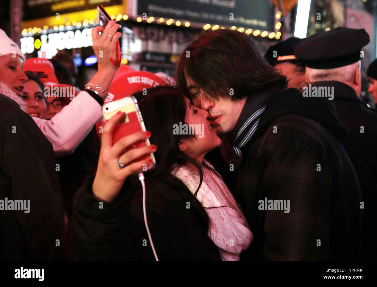 Un homme et une femme s'ils s'embrassent comme selfies à Times Square après minuit le soir du Nouvel An à New York le 1er janvier 2015. Environ un million de fêtards s'élevait à Times Square pour regarder le ballon et d'apporter de la nouvelle année le premier jour de 2015. UPI/John Angelillo Banque D'Images
