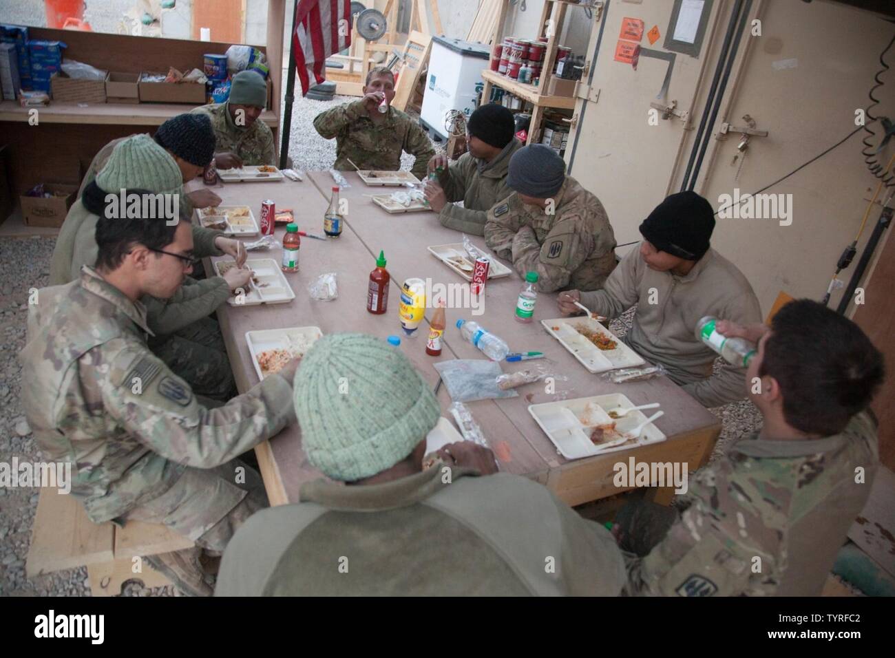 Les soldats de l'Armée américaine affecté à 1e Peloton du 3e bataillon du 321e Batterie en régiment d'artillerie de 18e Brigade d'artillerie de rassembler tous les soirs pour le dîner à l'Aérodrome de Qayyarah, ouest de l'Irak, 22 novembre 2016. Une coalition de nations régionales et internationales se sont associées pour permettre aux forces iraquiennes pour contrer l'État islamique d'Irak et du Levant, rétablir les frontières de l'Iraq et de re-prendre du terrain perdu donc de restaurer la stabilité et la sécurité régionales. Banque D'Images