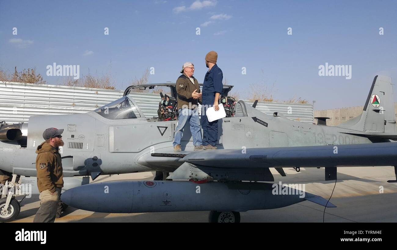 Un entrepreneur en entretien, serre la main avec un Afghan Air Force responsable d'aéronefs sur l'aile d'un A-29 Super Tucano à Hamid Karzaï, l'aéroport international de Kaboul, Afghanistan, le 23 novembre 2016. Les mainteneurs AAF a récemment effectué les 600 premières heures d'une inspection de l'avion A-29. Les responsables ont été en mesure de terminer l'inspection de trois semaines avec un minimum d'aide de la part des entrepreneurs. Banque D'Images