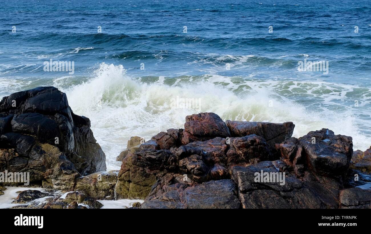 Éclaboussures des vagues sur une formation rocheuse à la plage Banque D'Images