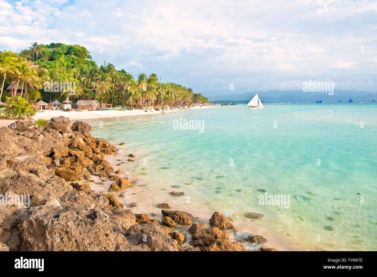 Tropical Beach au coucher du soleil avec des pierres et de palmiers Banque D'Images