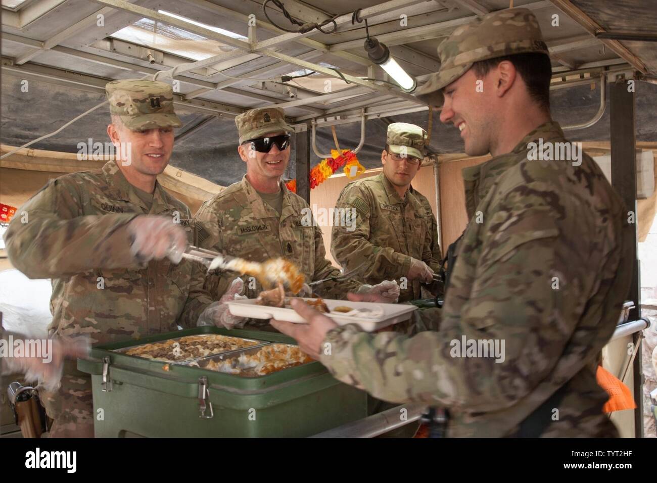 Les soldats de l'armée américaine détenant des postes de commandement des soldats servent le dîner de Thanksgiving à l'Aérodrome de Qayyarah West, l'Irak, 24 novembre 2016. Une coalition de nations régionales et internationales se sont associées pour permettre aux forces de sécurité iraquiennes pour contrer État islamique d'Irak et du Levant, rétablir les frontières de l'Iraq et de re-prendre du terrain perdu donc de restaurer la stabilité et la sécurité régionales. Banque D'Images