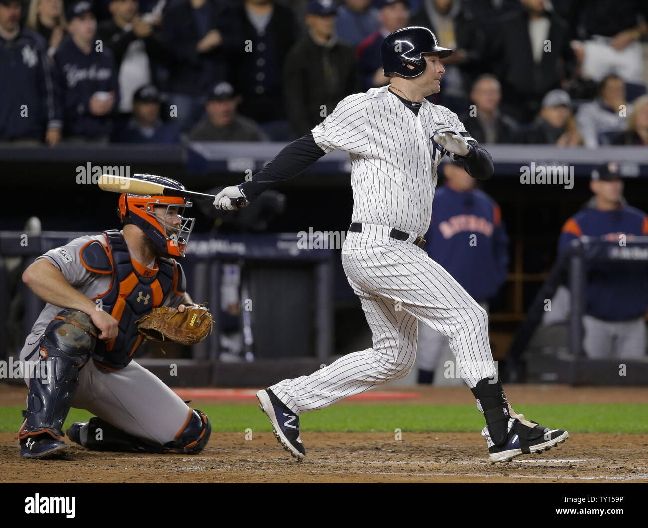 New York Yankees batter Chase Headley hits un RBI seul en face d'Astros de Houston catcher Evan Gattis (L) dans la quatrième manche dans le jeu 3 de la MLB Playoffs 2017 American League Championship Series au Yankee Stadium de New York le 16 octobre 2017. Photo par Ray Stubblebine/UPI Banque D'Images