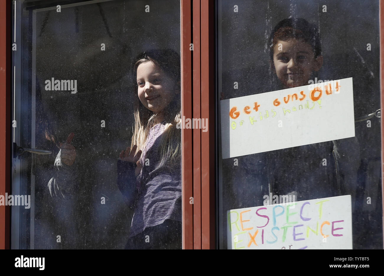 Les enfants occupent des panneaux à partir d'une fenêtre sur Central Park West, qui voient les manifestants à la Marche pour la vie de notre manifestation à New York le 24 mars 2018. La ville de New York. Des centaines de milliers d'enfants et d'adultes à travers le pays sont attendus pour participer à des rassemblements samedi dans le cadre de la marche pour notre vie mouvement qui est né de la Saint-Valentin fusillade dans un parc, en Floride, qui a tué 17 étudiants et membres du personnel. Photo de John Angelillo/UPI Banque D'Images