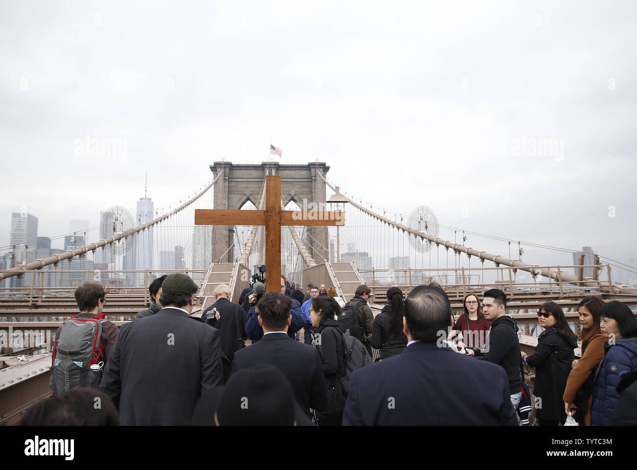 Une croix en bois est maintenu et ouvre la voie à la façon de la croix qui mène une procession sur le pont de Brooklyn qui passe par Zucotti Park et conclut à l'église Saint Pierre sur la rue Barclay le 30 mars 2018 dans la ville de New York. Chemin de la Croix comprend des passages de l'Évangile, la musique chorale et lectures choisies à contempler la souffrance, la mort et la résurrection de Jésus Christ. Le dimanche de Pâques est l'une des plus festives entre les chrétiens dans le monde entier. Elle commémore la résurrection du Christ Jésus de la mort. Photo de John Angelillo/UPI Banque D'Images Une croix en bois est maintenu et ouvre la voie à la façon de la croix qui mène une procession sur le pont de Brooklyn qui passe par Zucotti Park et conclut à l'église Saint Pierre sur la rue Barclay le 30 mars 2018 dans la ville de New York. Chemin de la Croix comprend des passages de l'Évangile, la musique chorale et lectures choisies à contempler la souffrance, la mort et la résurrection de Jésus Christ. Le dimanche de Pâques est l'une des plus festives entre les chrétiens dans le monde entier. Elle commémore la résurrection du Christ Jésus de la mort. Photo de John Angelillo/UPI Banque D'Images