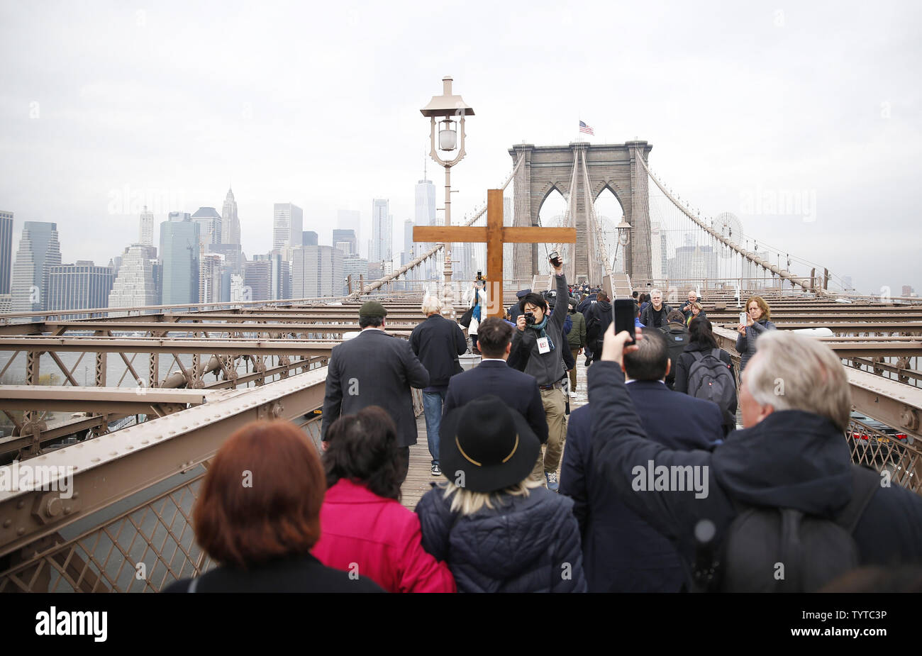 Une croix en bois est maintenu et ouvre la voie à la façon de la croix qui mène une procession sur le pont de Brooklyn qui passe par Zucotti Park et conclut à l'église Saint Pierre sur la rue Barclay le 30 mars 2018 dans la ville de New York. Chemin de la Croix comprend des passages de l'Évangile, la musique chorale et lectures choisies à contempler la souffrance, la mort et la résurrection de Jésus Christ. Le dimanche de Pâques est l'une des plus festives entre les chrétiens dans le monde entier. Elle commémore la résurrection du Christ Jésus de la mort. Photo de John Angelillo/UPI Banque D'Images Une croix en bois est maintenu et ouvre la voie à la façon de la croix qui mène une procession sur le pont de Brooklyn qui passe par Zucotti Park et conclut à l'église Saint Pierre sur la rue Barclay le 30 mars 2018 dans la ville de New York. Chemin de la Croix comprend des passages de l'Évangile, la musique chorale et lectures choisies à contempler la souffrance, la mort et la résurrection de Jésus Christ. Le dimanche de Pâques est l'une des plus festives entre les chrétiens dans le monde entier. Elle commémore la résurrection du Christ Jésus de la mort. Photo de John Angelillo/UPI Banque D'Images