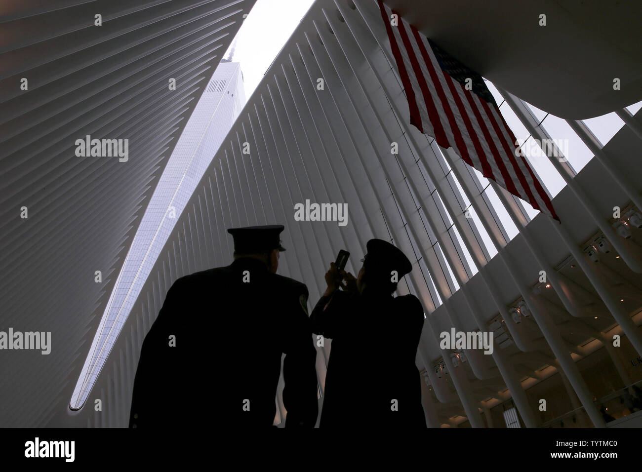 Deux pompiers FDNY arrêter près d'un drapeau américain pour prendre une photo de One World Trade Center au World Trade Center station Oculus sur le 17e anniversaire des attaques terroristes sur le World Trade Center à Ground Zero à New York, le 11 septembre 2018. Photo de John Angelillo/UPI Banque D'Images