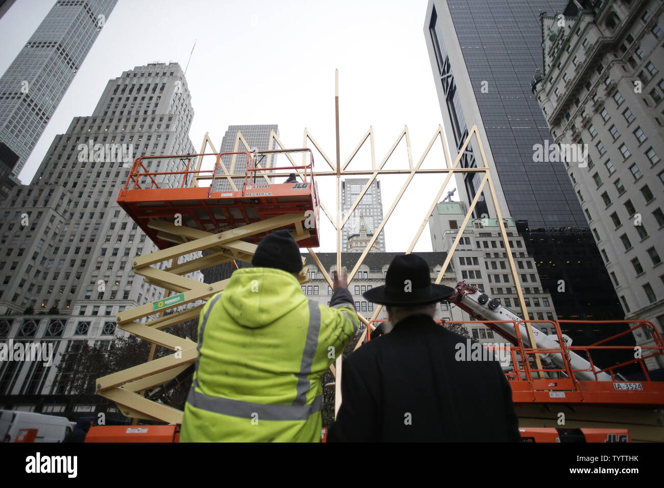 Un travailleur et directeur de l'organisation de jeunesse Lubavitch Parrain du plus grand monde Rabbi Shmuel Menorah Butman regardez comme assemblée de la plus grande Menorah conclut dans célébration de Hanoucca (Hanoukka) à l'extérieur de l'hôtel Plaza sur la 5e Avenue à New York le 30 novembre 2018. La menorah est certifié par Guinness World Records comme le plus grand. Photo de John Angelillo/UPI Banque D'Images