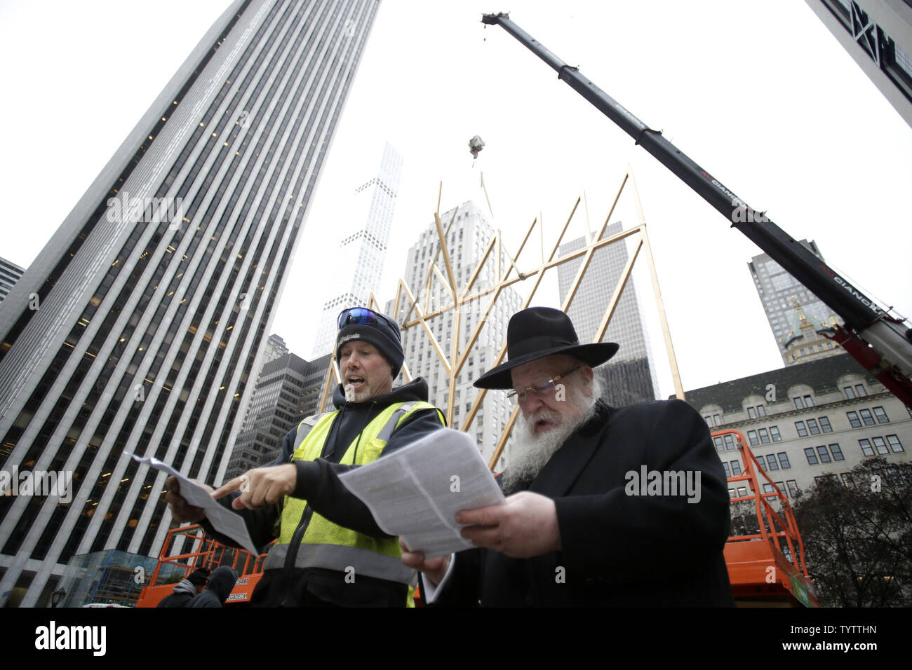 Un travailleur est avec le directeur de l'organisation de jeunesse Lubavitch Parrain du monde plus grande Menorah Rabbi Chmouel Butman comme assemblée de la plus grande Menorah conclut dans célébration de Hanoucca (Hanoukka) à l'extérieur de l'hôtel Plaza sur la 5e Avenue à New York le 30 novembre 2018. La menorah est certifié par Guinness World Records comme le plus grand. Photo de John Angelillo/UPI Banque D'Images