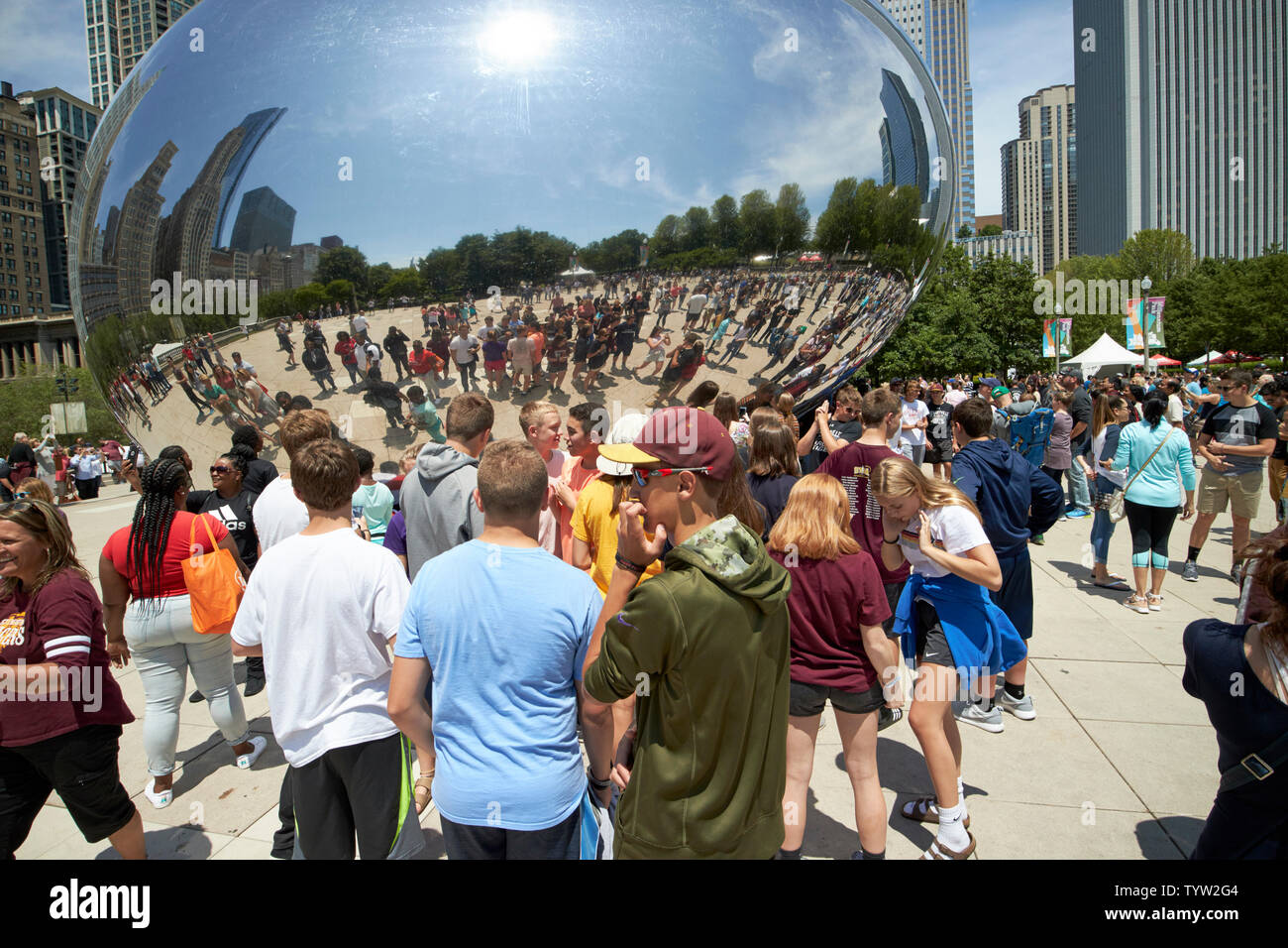 Groupes de jeunes visiteurs et touristes de Millennium Park un samedi matin en été prendre des photos et vos autoportraits près de la Cloud Gate bean Banque D'Images