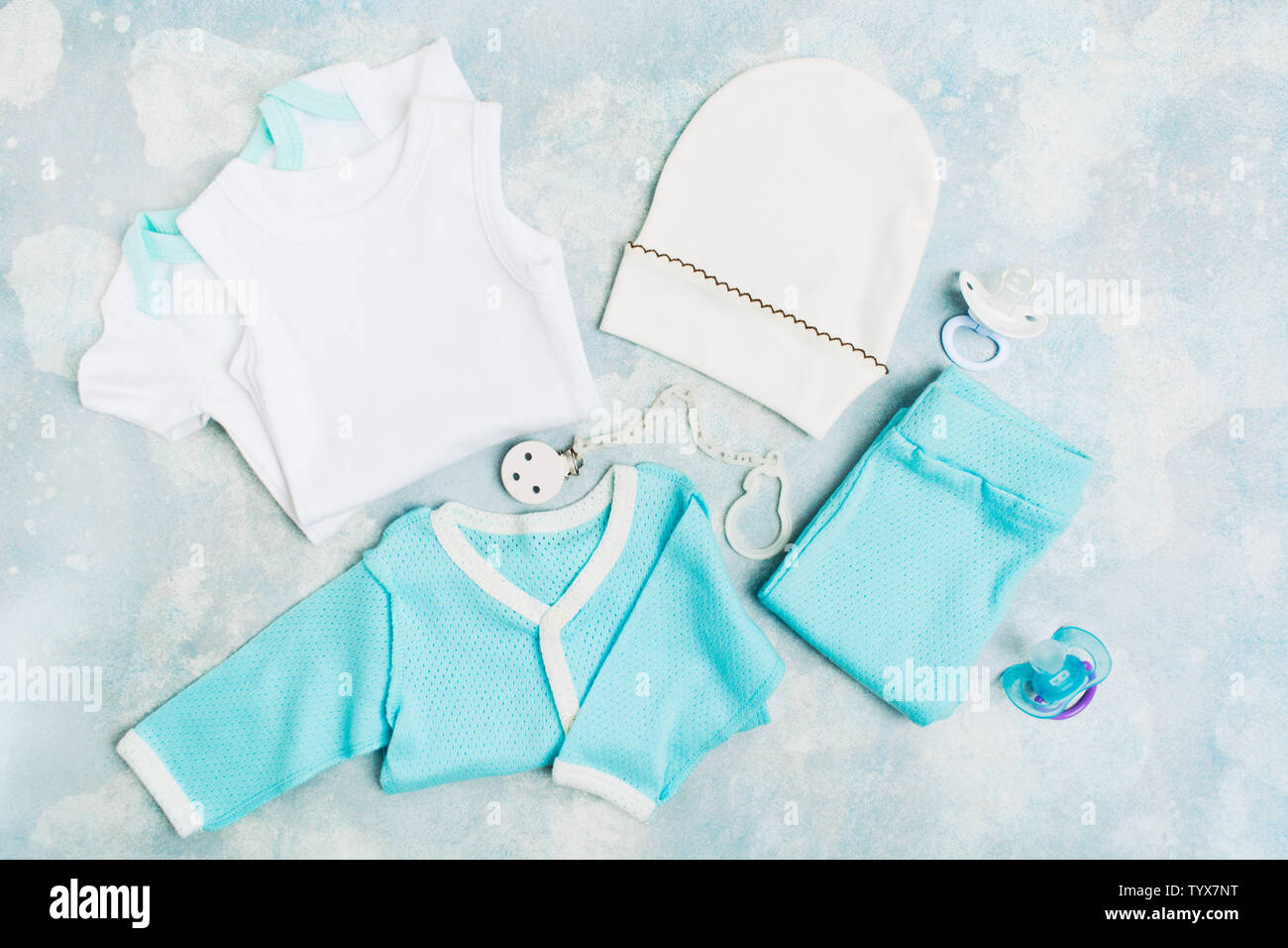 Vêtements de bébé nouveau-né body blanc - bleu, chemise, pantalon bleu,  blanc hat et les sucettes avec support bleu sur fond texturé. Concept de  douche de bébé Photo Stock - Alamy