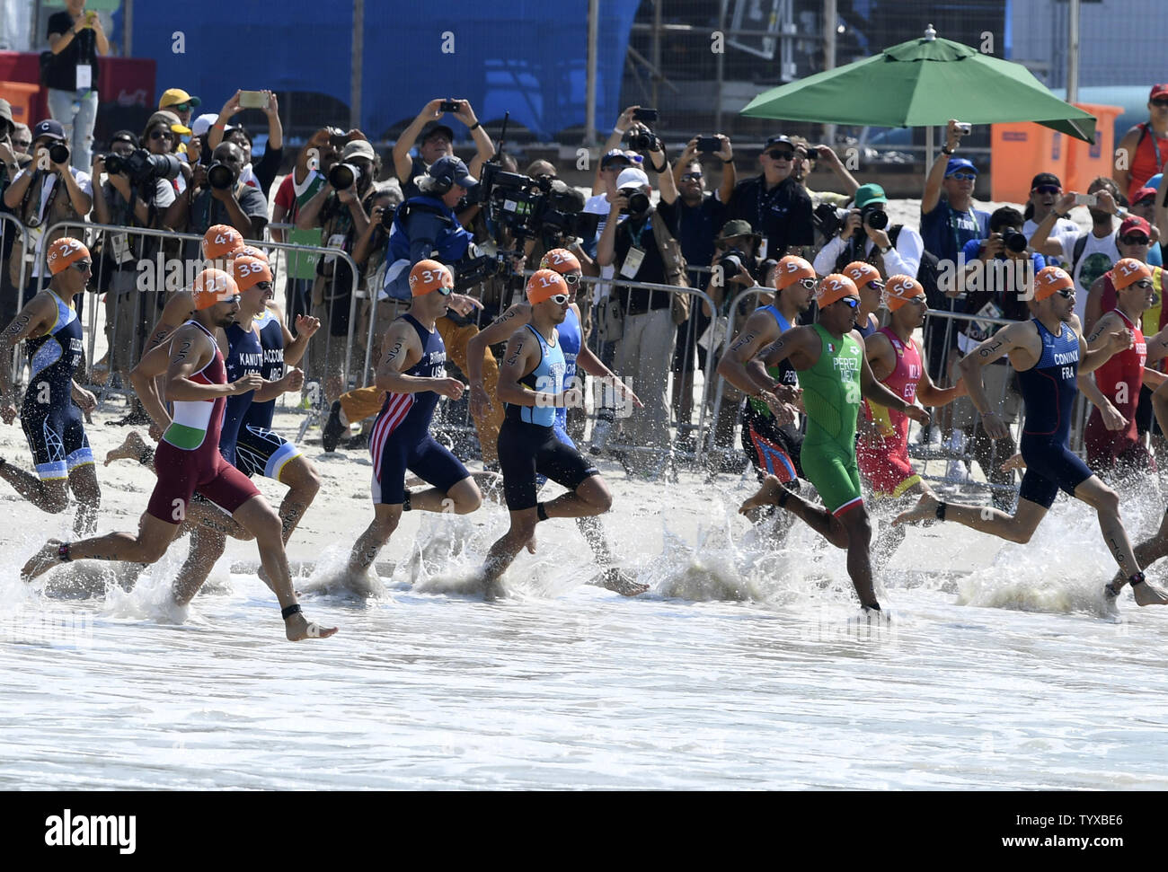 L'athlète de sauter dans l'eau qu'ils commencent la partie natation du triathlon au fort Copacabana à Rio de 2016 Jeux Olympiques d'été à Rio de Janeiro, Brésil, le 18 août 2016. Les frères de Grande-Bretagne Alistair Brownlee a remporté la médaille d'or, Jonathan Brownlee a remporté l'argent et de l'Afrique du Sud a gagné le bronze Henri Schoeman. Photo de Mike Theiler/UPI Banque D'Images