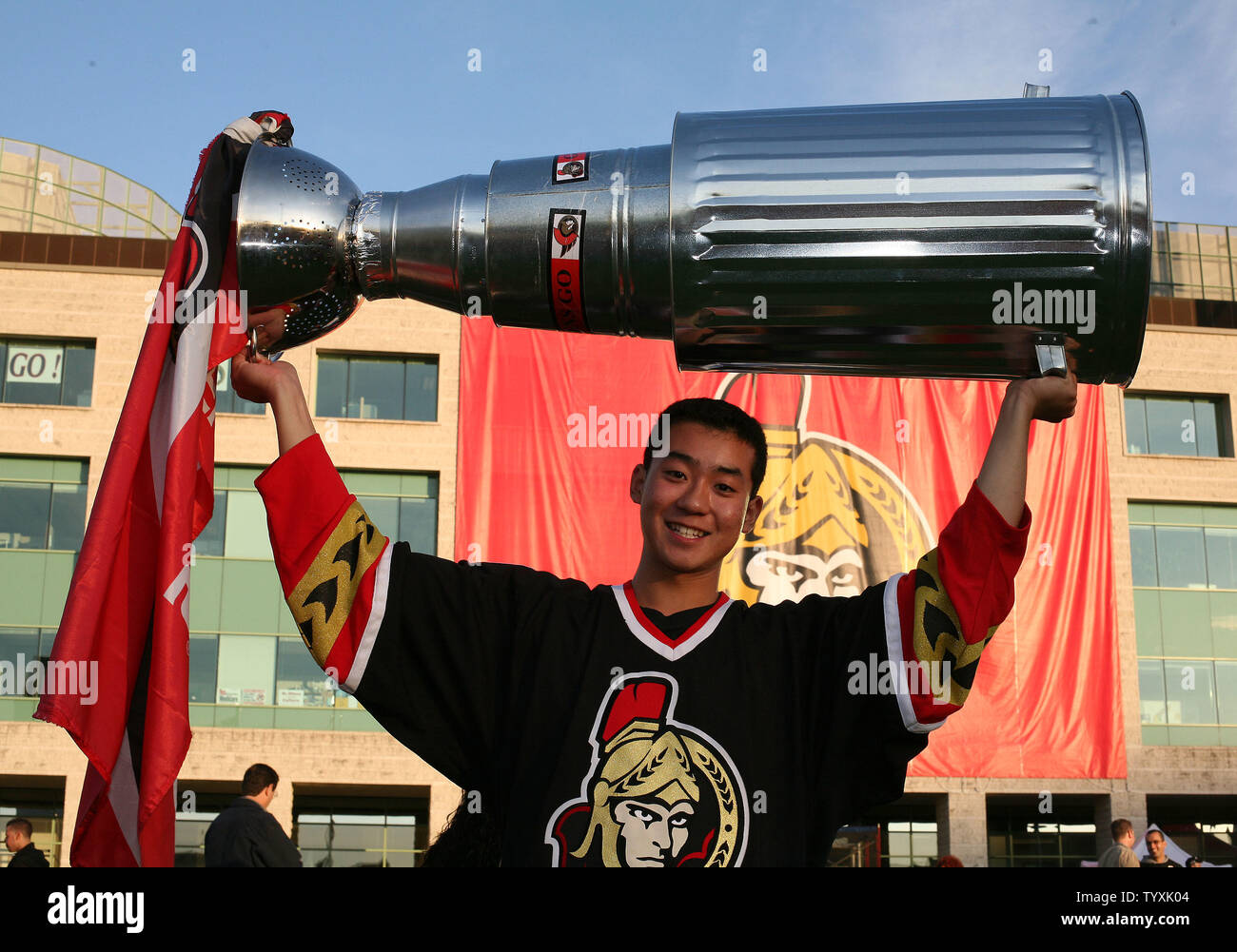 Partisan des Sénateurs d'Ottawa, Kelvin Hsia monte sa coupe Stanley à la maison avant le début de la partie 5 de la finale de la coupe Stanley à la Place des festivals à l'extérieur de l'Hôtel de Ville d'Ottawa le 6 juin 2007. Plus de dix mille fans se sont réunis pour regarder le match à l'extérieur, sur deux grands écrans avec l'espoir de ramener la Coupe Stanley de retour à Ottawa après 80 ans. (Photo d'UPI/Grace Chiu). Banque D'Images