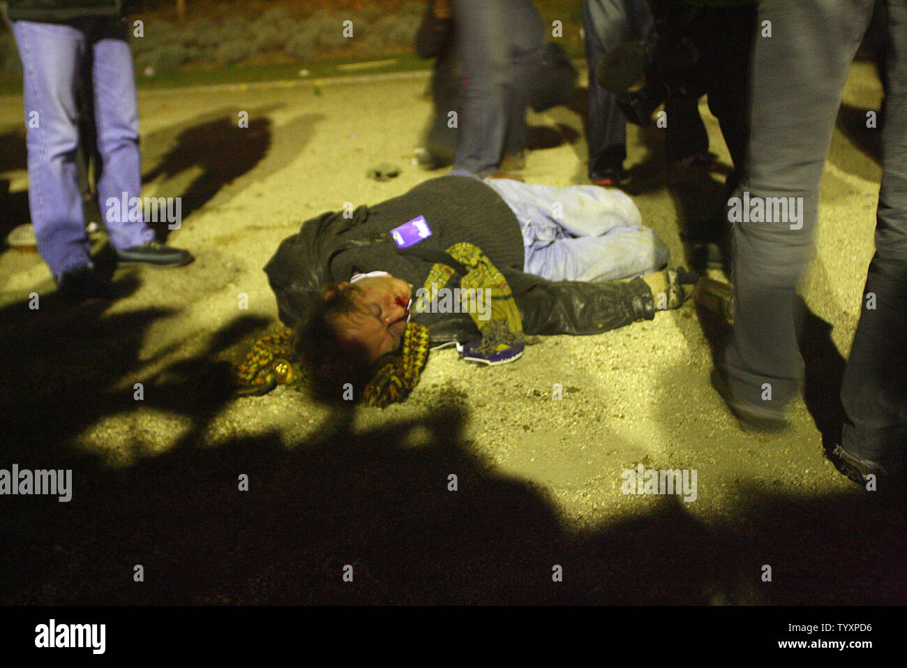 Un homme blessé qui se trouve sur le terrain aftger d'être battu par la police anti-émeutes lors d'un affrontement après des violences ont éclaté à la suite d'une grande manifestation à Paris le 18 mars 2006. Quelques 400 000 manifestants sont descendus dans la rue pour protester contre la mise en œuvre de la Contrat Première Embauche (CPE) applicables aux personnes de moins de 26 ans ce qui implique un contrat de travail ne peut être terminé dans les deux premières années sans explication. (Photo d'UPI/Eco Clement) Banque D'Images