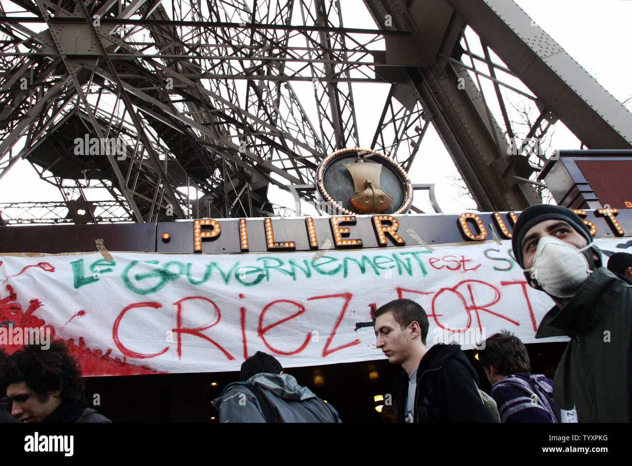 Environ 200 étudiants des écoles secondaires tenir un meeting de protestation contre le Contrat Première Embauche (CPE) sous la Tour Eiffel à Paris lundi, 3 avril 2006. Les étudiants a bloqué l'entrée du monument. Les manifestants français, se déclarant au bord de la victoire, l'espoir de rassembler au moins un million de personnes à l'échelle nationale pour les marches et les grèves mardi contre une loi, pour endiguer le chômage, qui a plongé le pays dans la crise. Banner se lit "le gouvernement est sourd, crier plus fort.' (UPI/Photo William Alix) Banque D'Images
