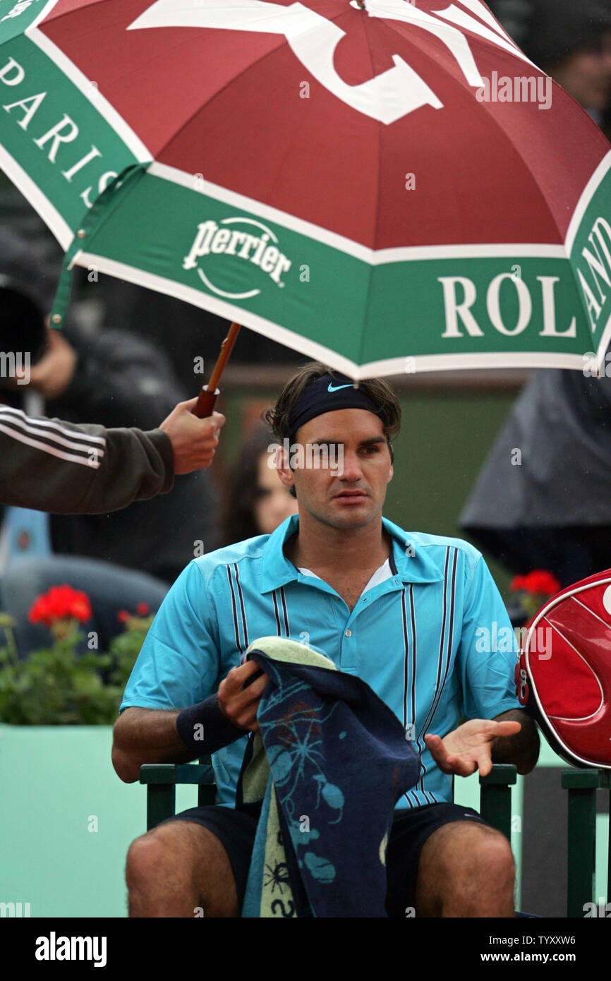 Au classement suisse Roger Federer s'abrite sous un parapluie après la  pluie a interrompu son premier match contre Michael Russell, de l'US au  cours de l'Open de France de Roland Garros, près